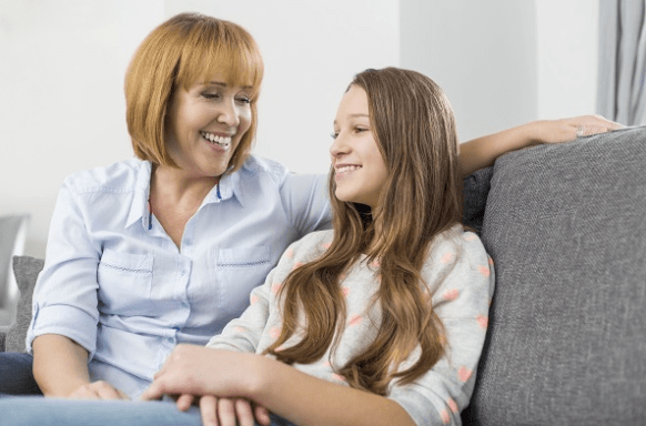 Mother and daughter smiling on a couch